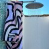 Beach towel hanging over a shower in scenic bright backdrop