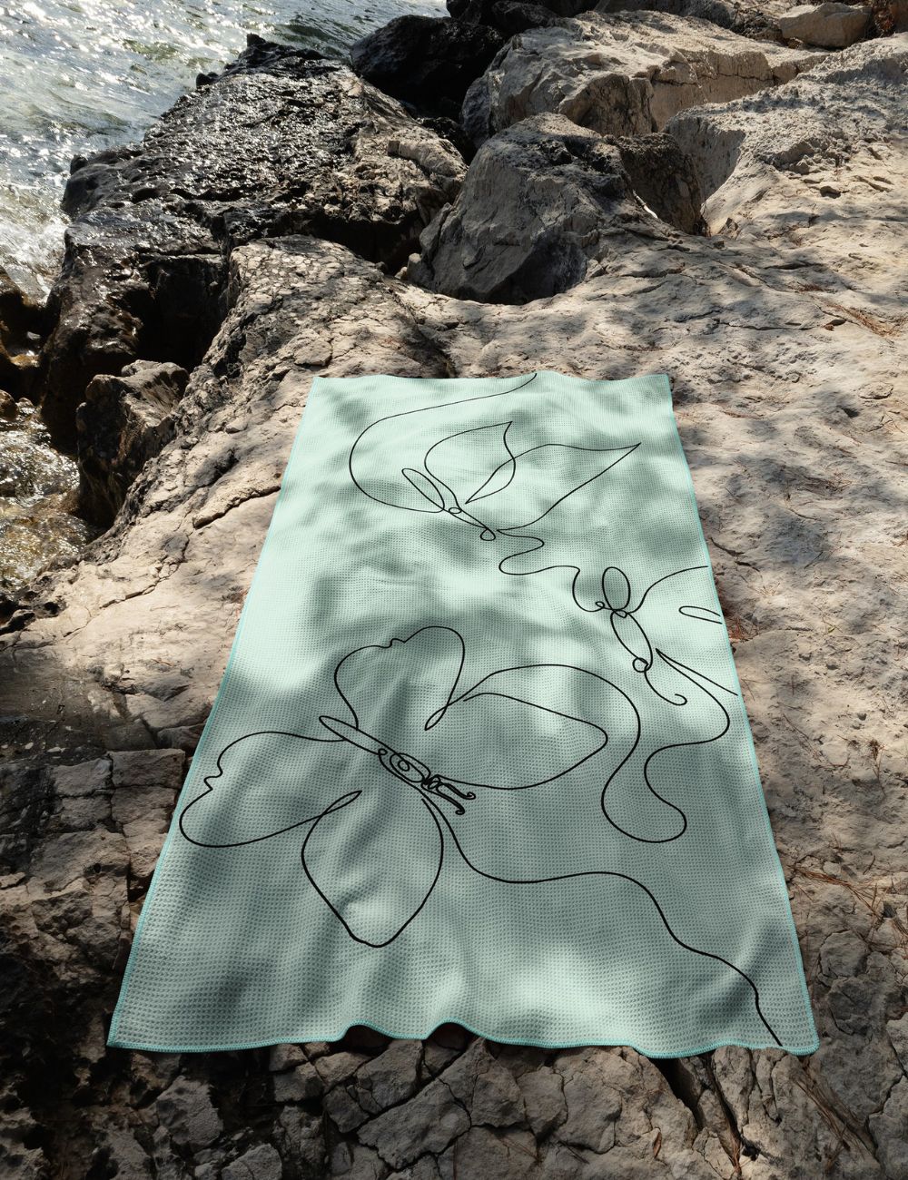45 Beach towel on a rock by the sea