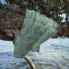 Beach towel hanging on a tree by the sea