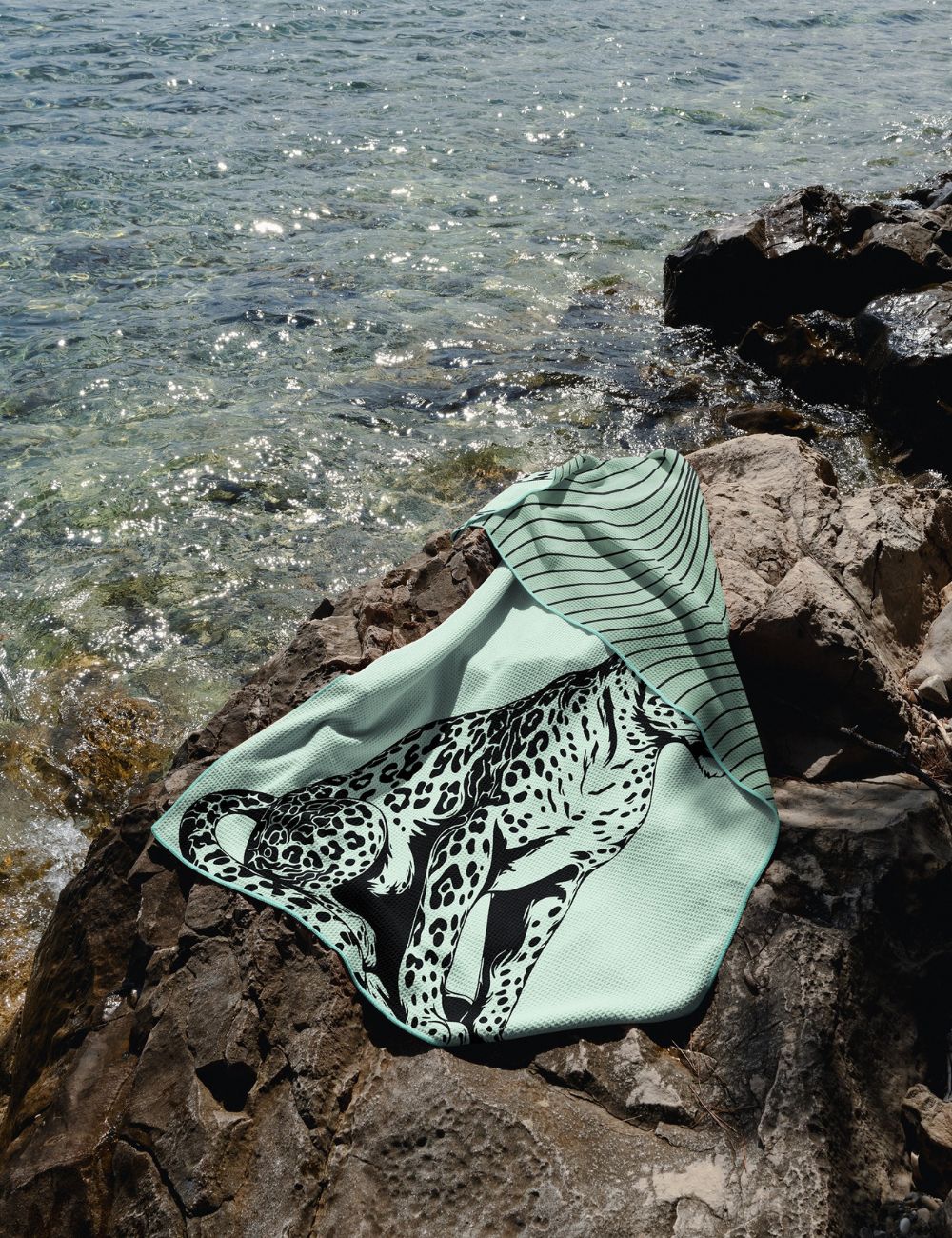 57 Beach towel on a rock by the sea